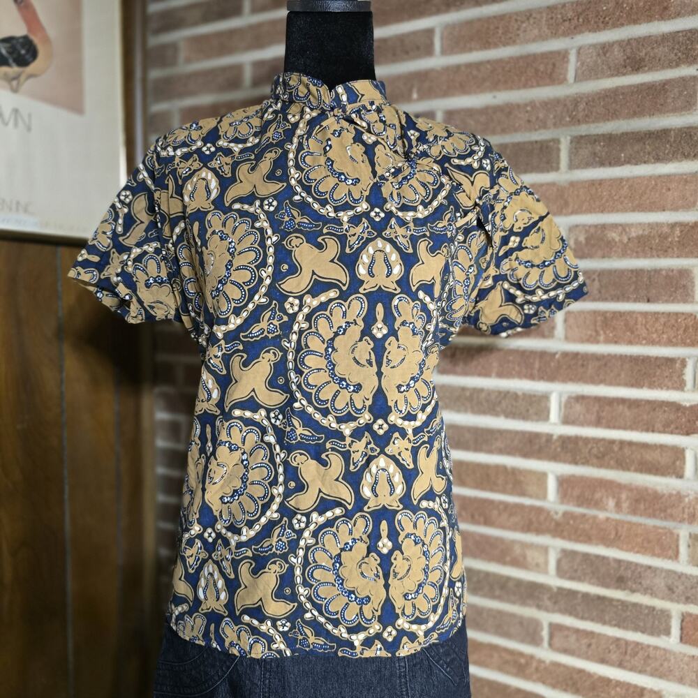 Exotic batik-style print with a short-sleeved silhouette and a high collar.
